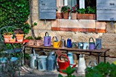 Collection of watering cans on a bench, Provence, France