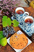 Snack time in the garden: Biscuit, white figs, black grapes, tea and heather bouquet