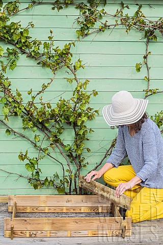 Woman_setting_up_a_mini_vegetable_garden_on_a_terrace_step_by_step