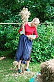 BUILDING A SCARECROW:FILL TROUSERS WITH STRAW