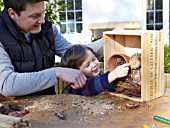 INSECT HOUSE BUILDING PROJECT WITH FATHER AND SON.  LOG PLACED IN BOX  STEP 24