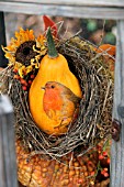 SQUASH PAINTED WITH ROBIN AND PLACED IN BIRDS NEST