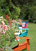 COLOURFUL CHAIRS IN GARDEN IN SUMMER