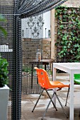 THE DRAWING ROOM GARDEN  URBAN LONDON GARDEN  CHAIN SCREEN DIVIDE WITH FURINTURE  DESIGNED BY: EARTH DESIGNS.
