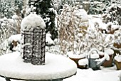 SNOW COVERED GARDEN TABLE WITH RUSTY IRON ORNAMENT