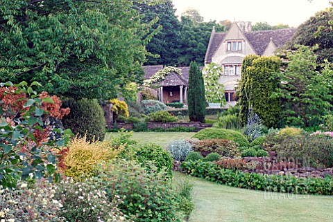 MIXED_BORDERS_AND_OLD_COTSWOLD_HOUSE_AT_CAMERS_OLD_SODBURY_BRISTOL