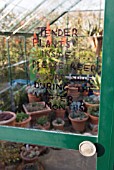 TENDER PLANTS SIGN ON GREENHOUSE DOOR