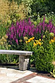 CURVED WOODEN BENCH IN THE HERBACEOUS BORDER AT RHS HARLOW CARR