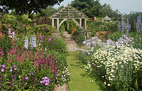 DEEP_BORDERS_OF_MIXED_COLOURS_GRASS_PATH_LEADING_TO_OAK_PERGOLA_AT_WOLLERTON_OLD_HALL