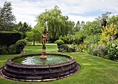 Rectangular water fountain with statue of boy in centre of lawn