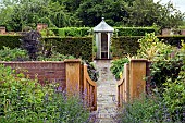 Open wooden gate, brick path leading to summerhouse
