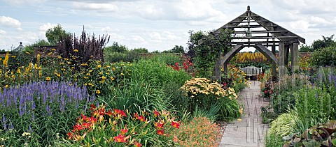 Deep_borders_of_hot_coloured_herbaceious_perennials_red_orange_yellow_and_blues