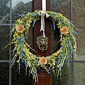 Artifcial flowers in wreath on front door