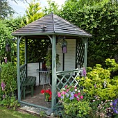 Wooden Gazebo containers planted with Petunias and Pelargoniums,