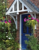 Two hanging baskets of summer flowering annuals hanging either side of front door