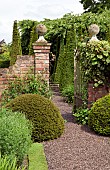 Gravel path through wrought iron gate leading to outstanding country garden