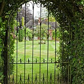 Looking at garden and house through wrought iron gate